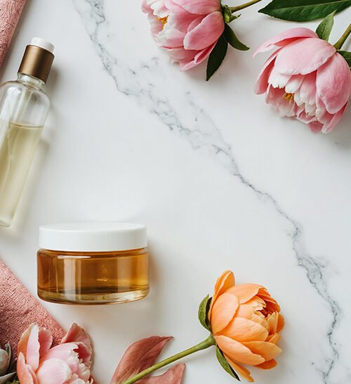 aesthetic-beauty-products-with-flowers-marble-background
